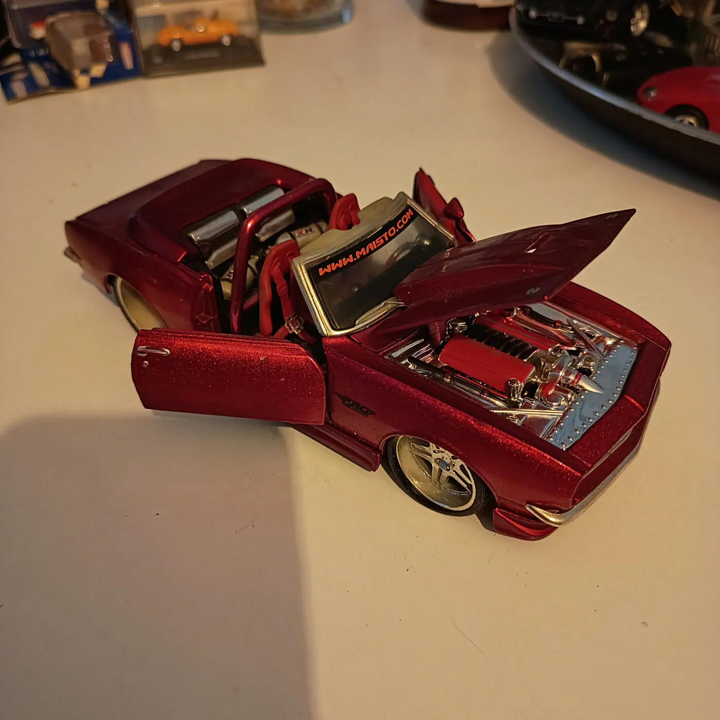 Rød modelbil cabriolet med åbne døre og motorhjelm