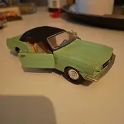 Grøn modelbil med sorte vinduer og åbne døre