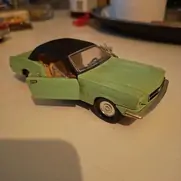 Grøn modelbil med sorte vinduer og åbne døre